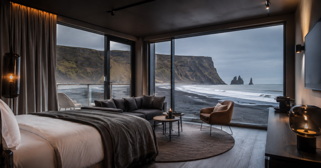 Luxury Black Beach Suites interior in Vik Iceland with panoramic ocean windows, Scandinavian design, and stunning volcanic coastline views