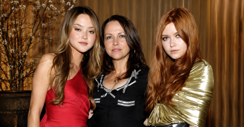 Pamela Hilburger posing with her daughters in a luxury indoor portrait, elegant fashion editorial style with warm lighting and premium background.