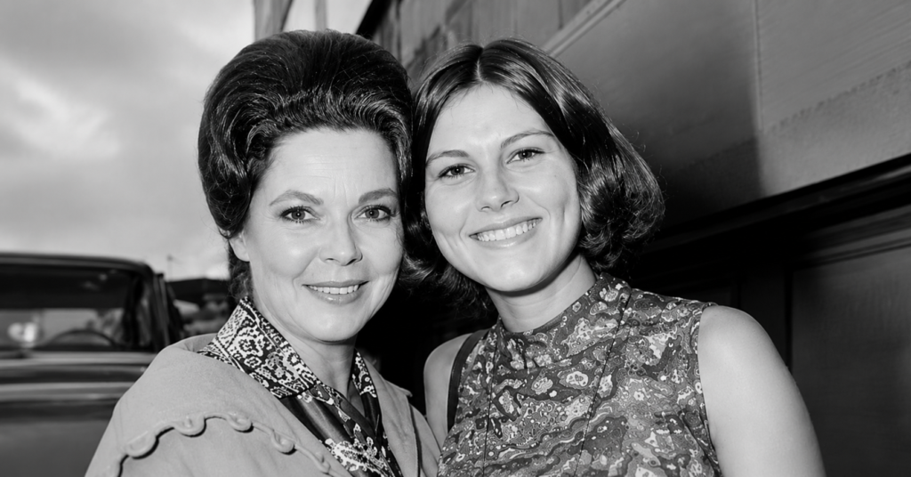 Vintage black-and-white portrait of Shirley Temple with her daughter Linda Susan Agar smiling together outdoors in a candid Hollywood-era photograph.