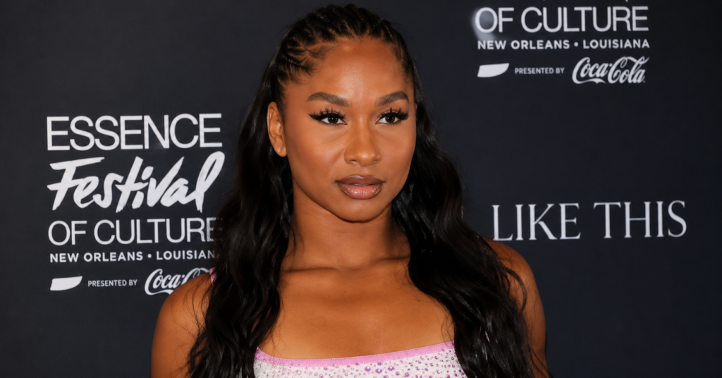 Jordan Chiles posing on the red carpet in a sparkling pink dress with sleek long hair, photographed at a high-profile entertainment event in a polished editorial style.