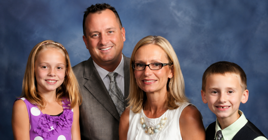 Maya Kowalski family portrait featuring a young girl with her parents and brother in a polished studio-style image with a soft blue background.Maya Kowalski: A clean, high-resolution family portrait showing Maya Kowalski with her parents and brother in a formal studio setting.
