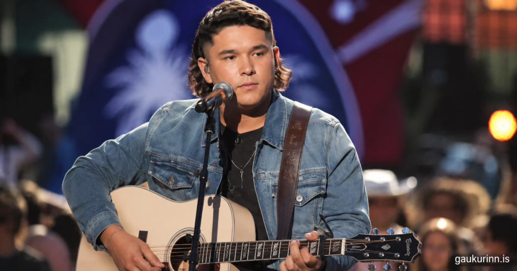 Caleb Kennedy American Idol contestant performing live with acoustic guitar during a country music concert, showcasing his signature singing style and stage presence.