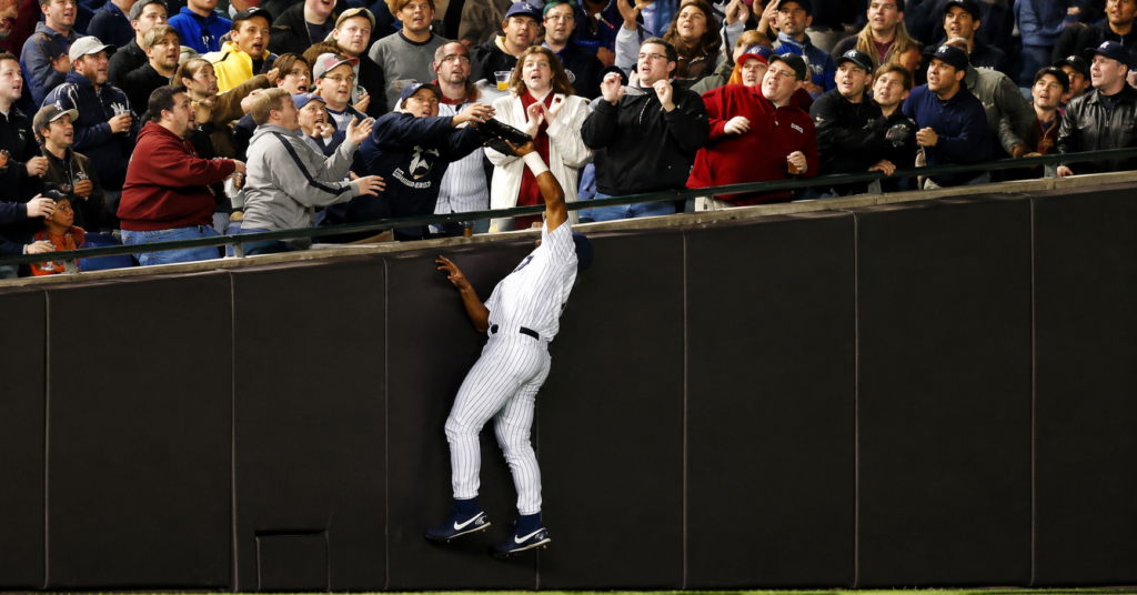 Steve Bartman incident at Wrigley Field as a fan reaches toward a foul ball near the outfield wall during a crucial MLB playoff game.