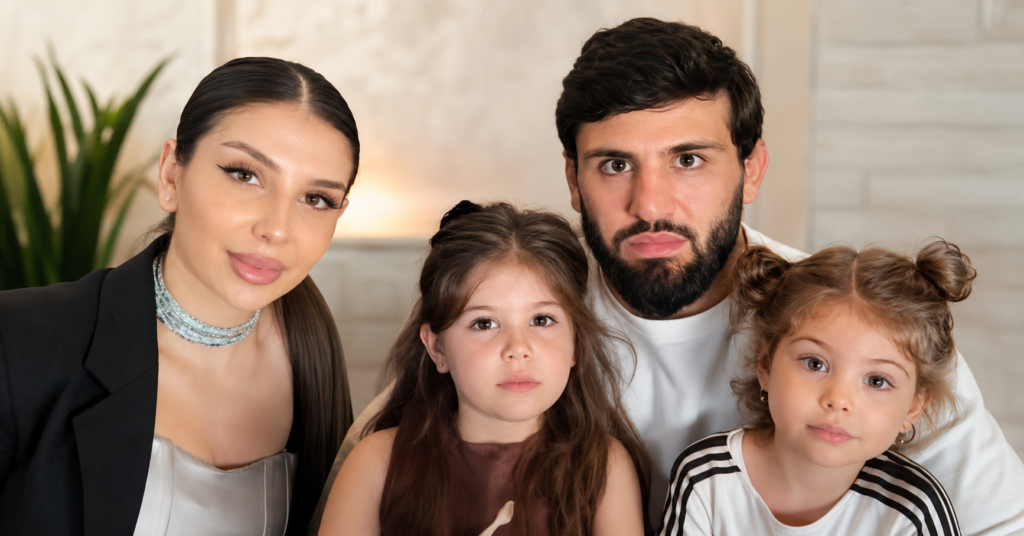 Arman Tsarukyan with his wife and two children posing together for a family portrait indoors.