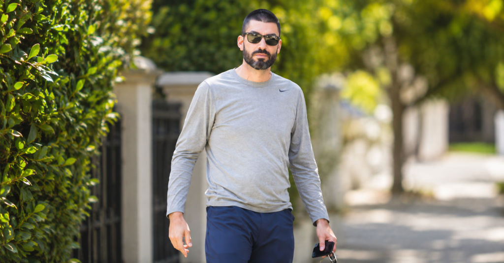 Scott Borgerson walking outdoors in casual athletic clothing with sunglasses on during daylight.